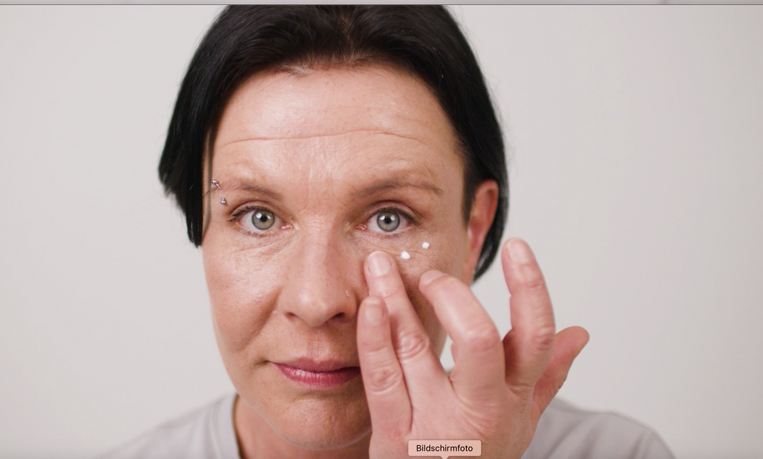 Model trägt sich Gerda Spillmann Anti Aging Augenregioncreme unterhalb des Auges auf